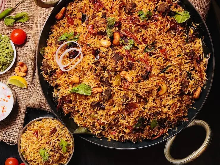 Biryani with cashews and herbs in a wide pan