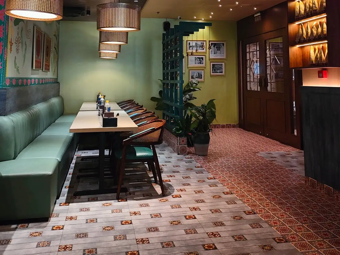 A bright dining room with green booths and patterned tiles
