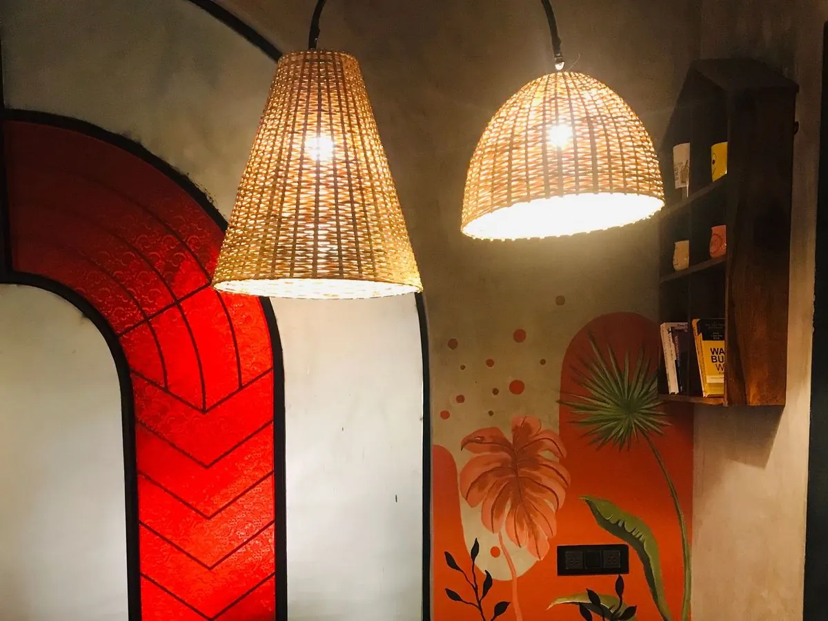 An empty wooden dining table under a wall of traditional art